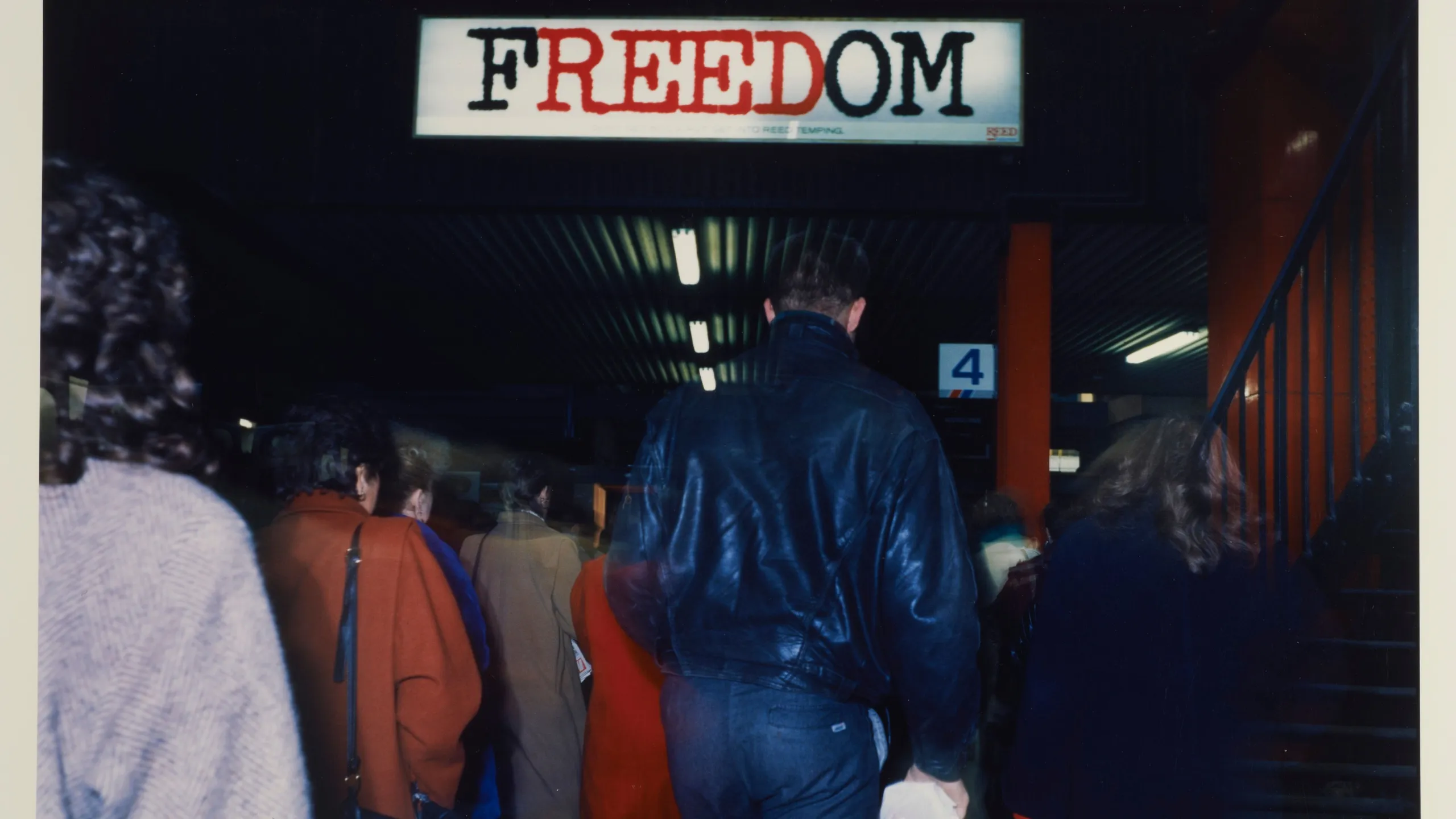 People walking away under a banner reading 'Freedom' (description, not title).
