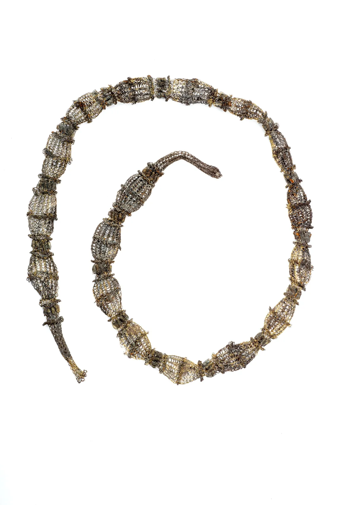 A long, segmented metallic object resembling a snake, composed of mesh-like sections, displayed against a white background.