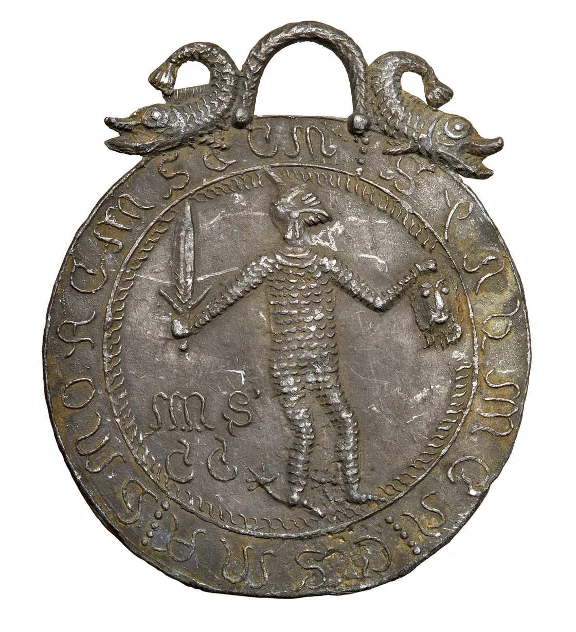 Medieval metal seal depicting a figure in armor holding a sword and scales, encircled by text and designs with two fish at the top.
