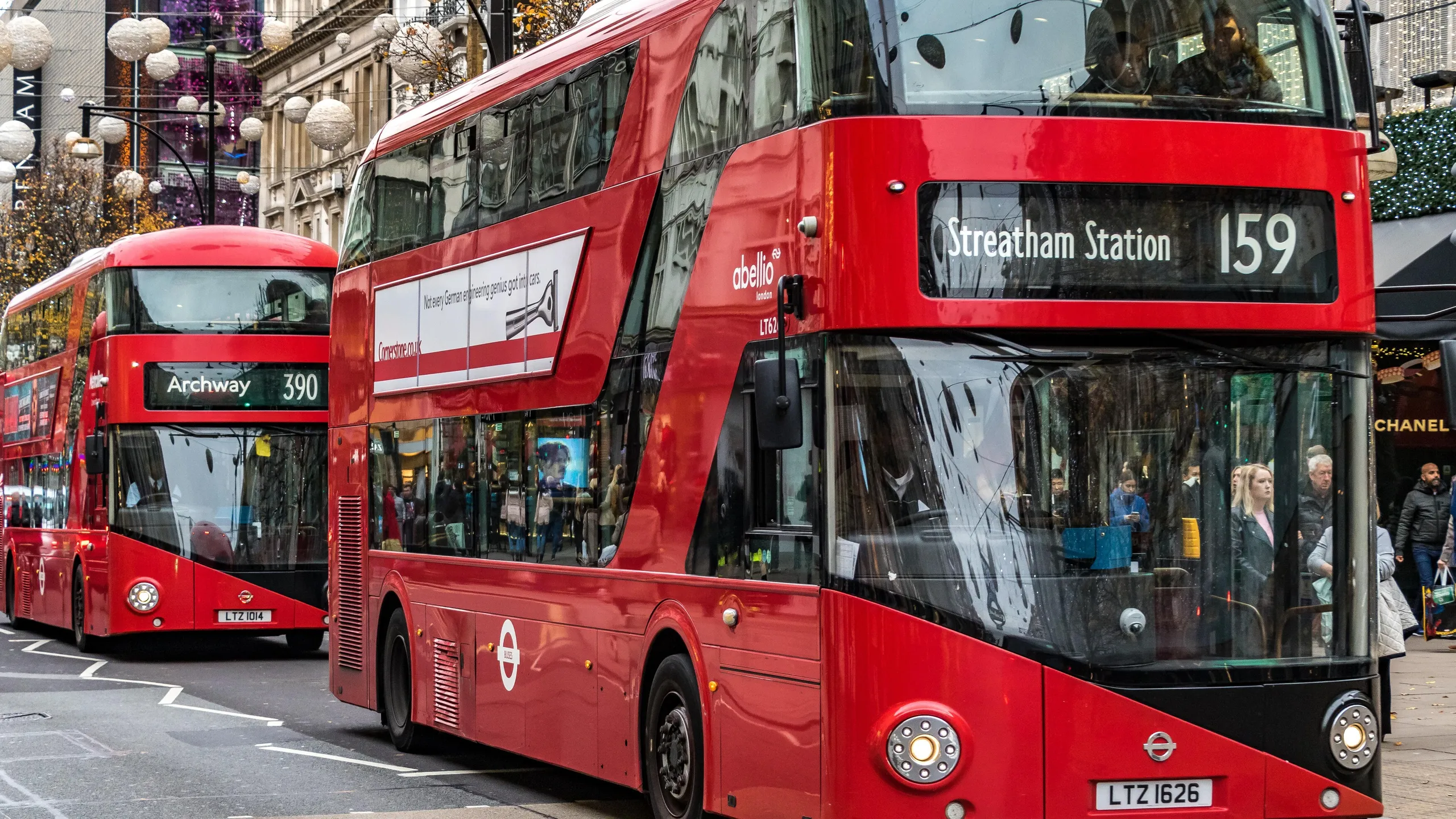 M65773 Two London buses moving along  on London's Oxford St ,London,UK