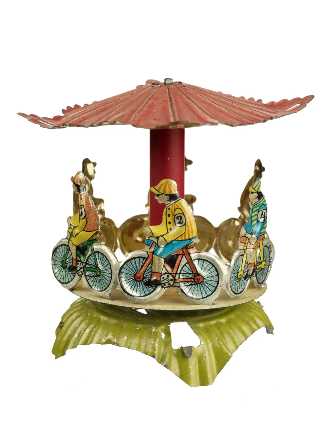 Vintage mechanical toy featuring cyclists riding under a red umbrella, set on a green wavy base, isolated on a white background.