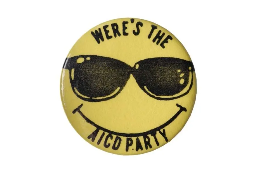 A yellow badge featuring a smiling face wearing sunglasses and the text "where's the party" in black letters.