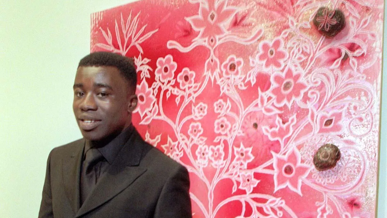 G4H3T8 Manchester born Chris Ofili Turner Prize winner announced at the Tate Gallery in london this evening (Tuesday). Chris stands in front of one of his winning exhibits Through The Grapevine. See PA Story. Photo by Toby Melville/PA.