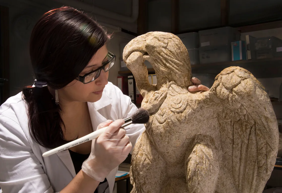 Conservator Luisa Duarte working on a stone eagle, 2013
