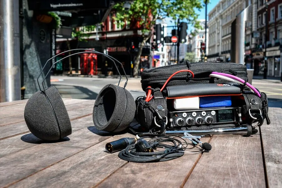 Portable audio recording equipment with headphones on an urban street, capturing the sounds of the city.
