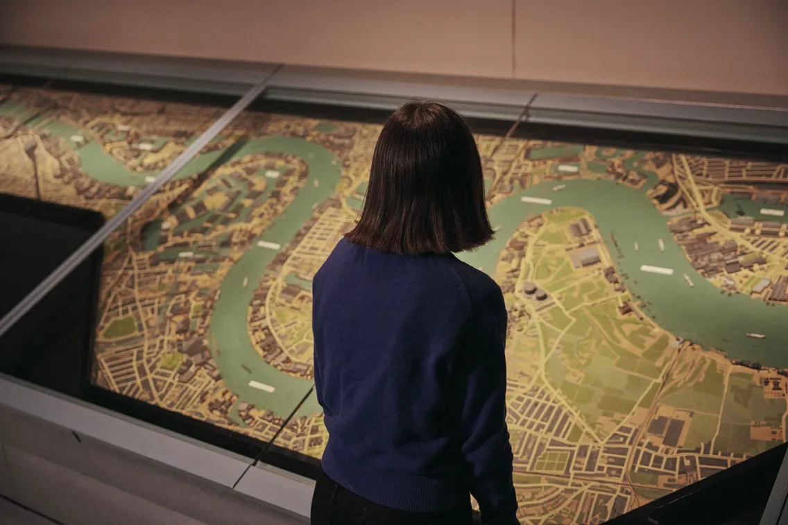 A visitor surveys a giant map of London in the Docklands at War Gallery at London Museum Docklands