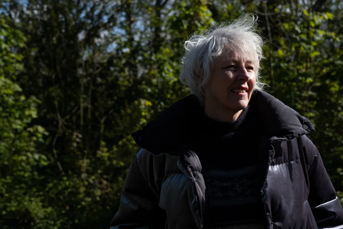 Sharon Ament, London Museum Director stands in a woodland smiling