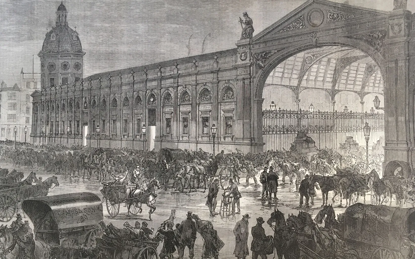 A crowded 19th-century train station with horse-drawn carriages, people, and luggage. The station has an ornate archway and extensive architectural details.