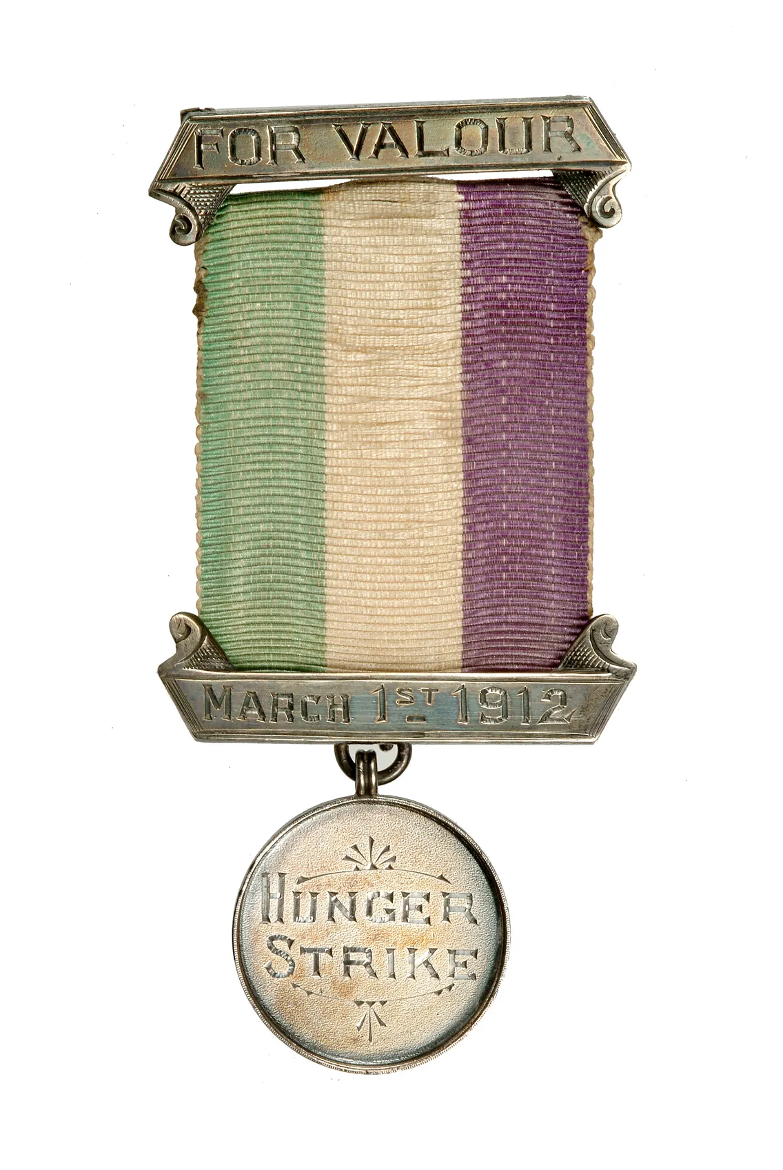 Vintage medal with a ribbon striped in green, white, and purple colors, labeled "for valour" and "march 1st 1912" at the top and "hunger strike" on the bottom medallion.
