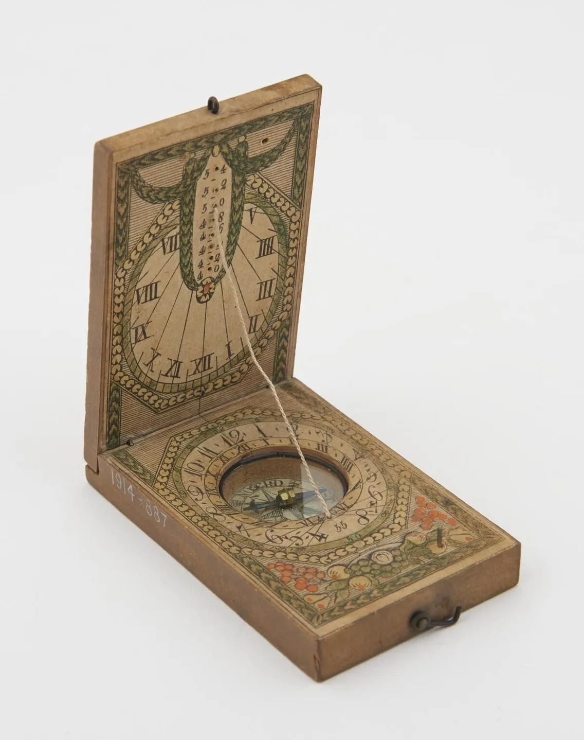 A vintage sundial compass in a decorative, hinged wooden case with Roman numerals and a string gnomon, displayed open.